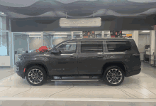 a gray suv with a red bow in front of a sign that says ' wagner '