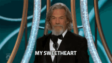 a man with long hair and a beard is giving a speech and says my sweetheart