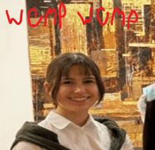 a woman is smiling in front of a painting that says wemp wimp