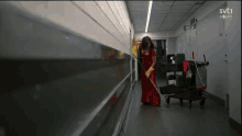 a woman in a red dress is mopping the floor in a hallway with svt1 written on the bottom