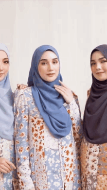 three women wearing hijabs pose for a picture