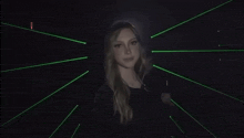 a woman is waving her hand in front of a green laser beam