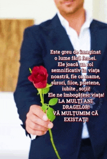 a man in a suit is holding a red rose with a greeting in another language