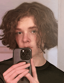 a young man is taking a selfie with his cell phone