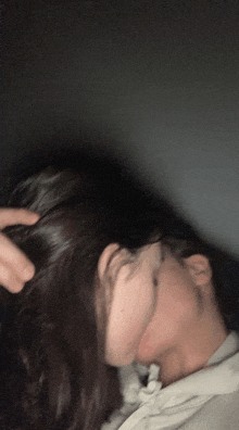 a blurry picture of a woman 's face with a man 's hand on her head