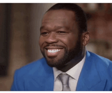 a man in a blue suit and tie is smiling