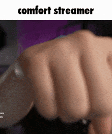 a close up of a person 's fist with the words comfort streamer written above it