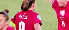 a soccer player wearing a red jersey with pajor on it