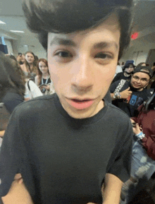 a young man wearing a black shirt with the letter e on it