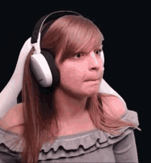 a woman wearing headphones is making a face