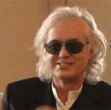 a close up of a man wearing sunglasses and a black suit