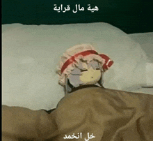 a doll is laying in a bed with arabic writing on the bottom