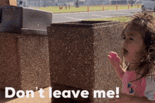 a little girl standing in front of a trash can with the words " do n't leave me " written on the bottom