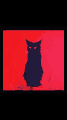 a black cat with red eyes is sitting on a red surface .