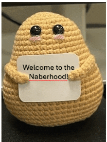 a stuffed animal holding a sign that says " welcome to the naberhood "