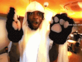 a man wearing a white hoodie and black paw gloves says nms subs 1818 on the bottom