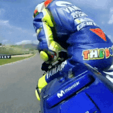 a man riding a motorcycle with the word movistar on the back