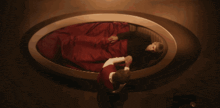 a man and a woman are laying in a oval bed