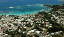 an aerial view of a small town on a hill overlooking the ocean