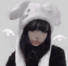 a girl is wearing a white bunny hat with bunny ears