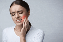 a woman has a toothache and is holding her face