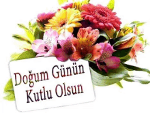 a bouquet of flowers with a card that says dogum gunun kutlu olsun on it .