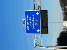 a blue highway sign that says amsterdam utrecht oosterbeek