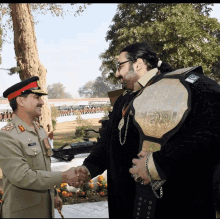 a man in a military uniform shakes hands with a man in a wrestling belt