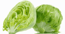 two heads of lettuce , one cut in half , on a white background .