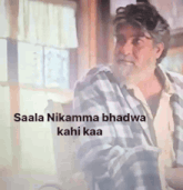 a man in a plaid shirt with the words saala nikamma bhadra kahi kaa on the bottom