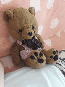 a teddy bear wearing a pink sweater and scarf