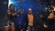 a wrestler named johnny tv is standing in front of two other men