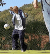 a man is kicking a soccer ball while another person watches
