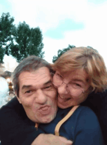 a man and a woman are posing for a picture and making funny faces