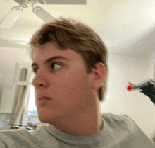 a close up of a person 's face with a ceiling fan behind him