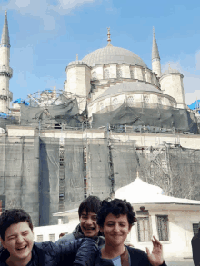 a group of young men are posing for a picture in front of a mosque