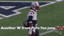 a football player is standing on a field with the words `` another w from pats fan june '' above him .