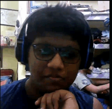 a young man wearing headphones and glasses is looking at the camera