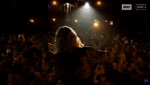 a man singing into a microphone on a stage with a sign that says ' a & m ' on it