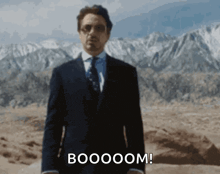 a man in a suit says boooom in front of a mountain