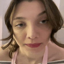 a close up of a woman 's face with a pink apron