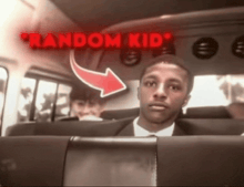 a man in a suit sits in the back seat of a bus with the words random kid behind him