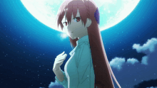 a girl with long red hair is standing in front of the moon
