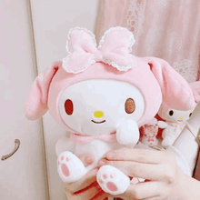 a person is holding a stuffed animal in their hands .