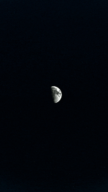 the moon is visible in the dark night sky .