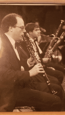 a man in a tuxedo is playing a clarinet