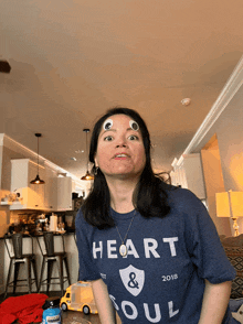 a woman wearing a blue shirt that says " heart & soul "