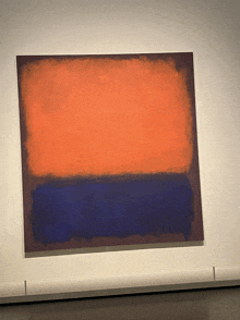 a large orange and blue painting on a white wall