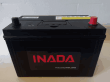 a black and red inada battery is sitting on a white surface