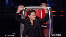 a man is sitting in a chair with his arms in the air and the words the voice behind him